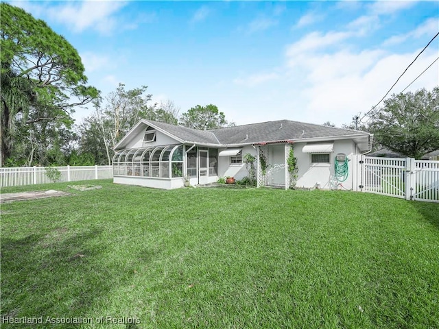 rear view of property with a sunroom and a lawn