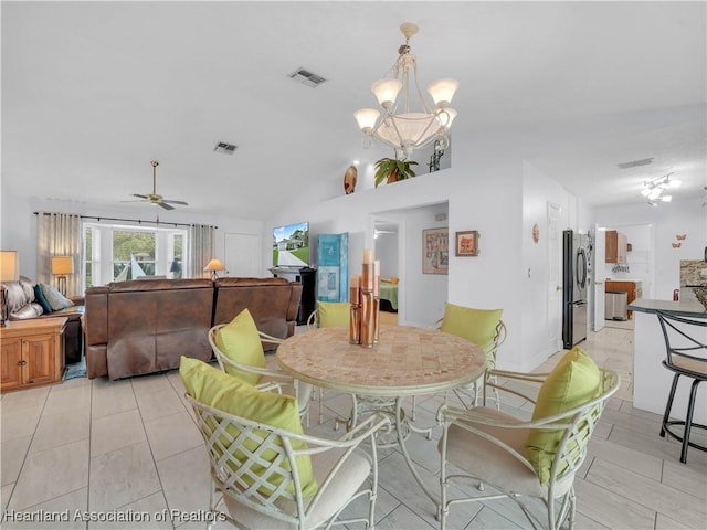 dining area with lofted ceiling, ceiling fan with notable chandelier, and light tile patterned floors