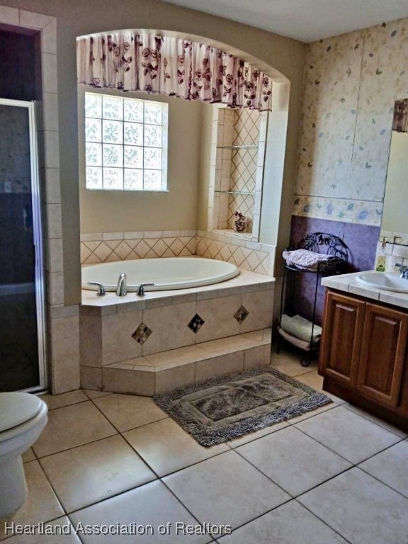 bathroom featuring vanity, a garden tub, tile patterned flooring, and a stall shower