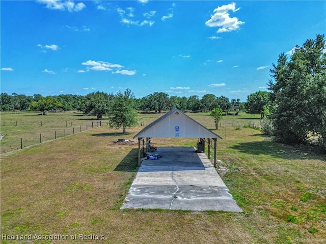 view of yard with fence, a carport, and driveway