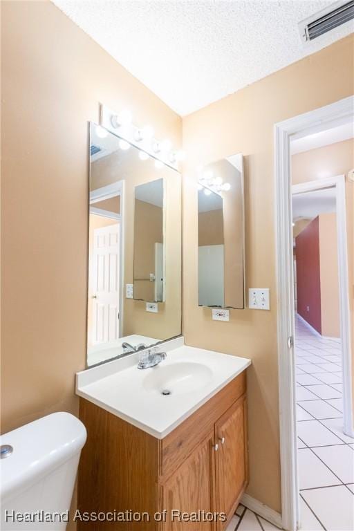 bathroom with vanity, tile patterned floors, a textured ceiling, and toilet