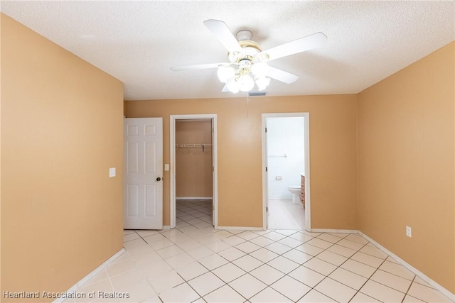 spare room with light tile patterned flooring, ceiling fan, and a textured ceiling