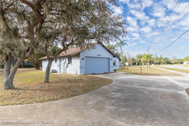 view of side of property featuring a garage and a yard