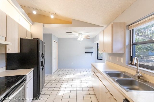 kitchen featuring lofted ceiling, sink, light brown cabinets, and light tile patterned floors