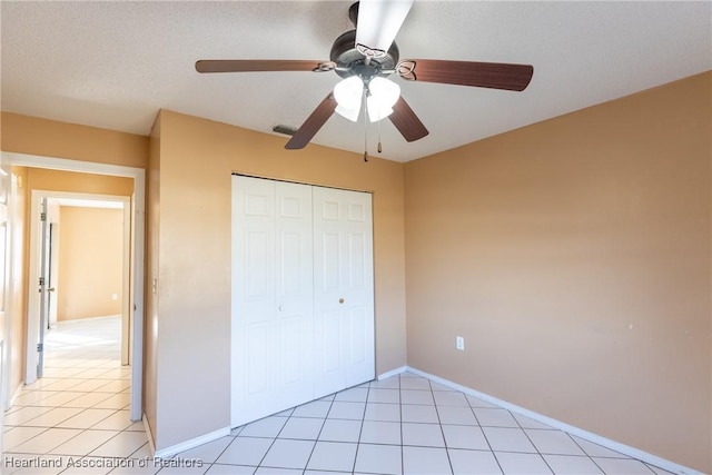 unfurnished bedroom featuring light tile patterned floors, a closet, and ceiling fan