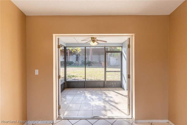 doorway to outside featuring light tile patterned floors and ceiling fan