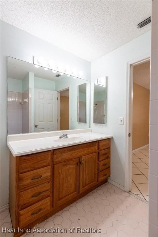 bathroom with tile patterned floors, vanity, and a textured ceiling