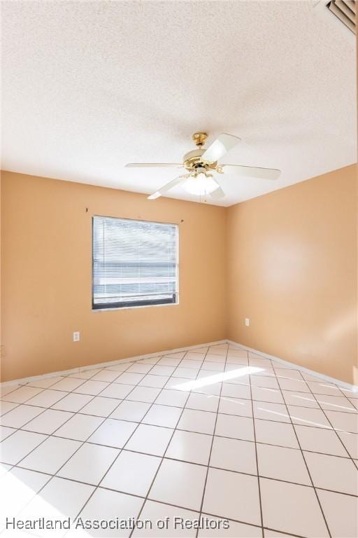 unfurnished room with ceiling fan, a textured ceiling, and light tile patterned floors