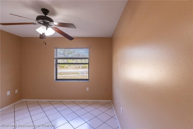 tiled empty room with ceiling fan and a textured ceiling