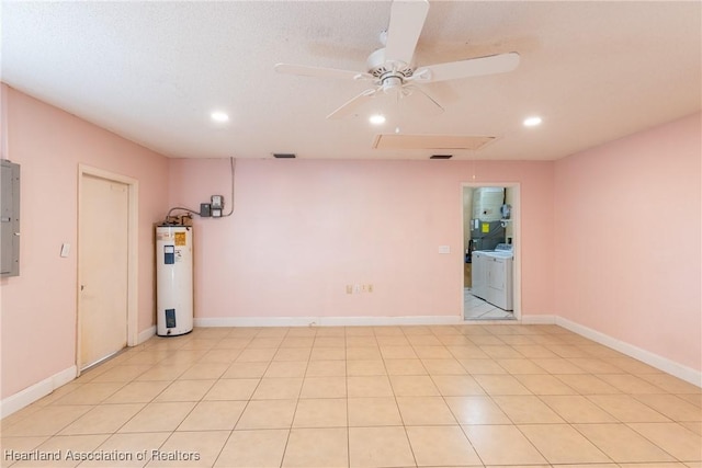 tiled empty room with water heater, electric panel, ceiling fan, washing machine and dryer, and a textured ceiling