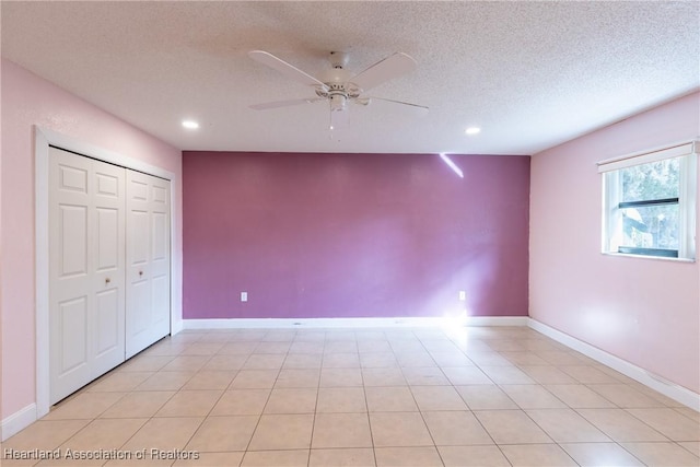 unfurnished bedroom featuring light tile patterned floors, a textured ceiling, a closet, and ceiling fan