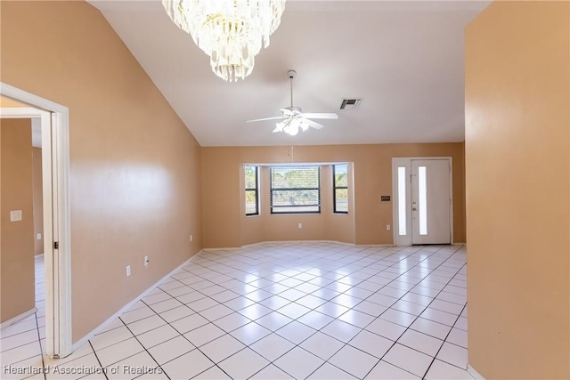 spare room featuring vaulted ceiling, ceiling fan with notable chandelier, and light tile patterned floors