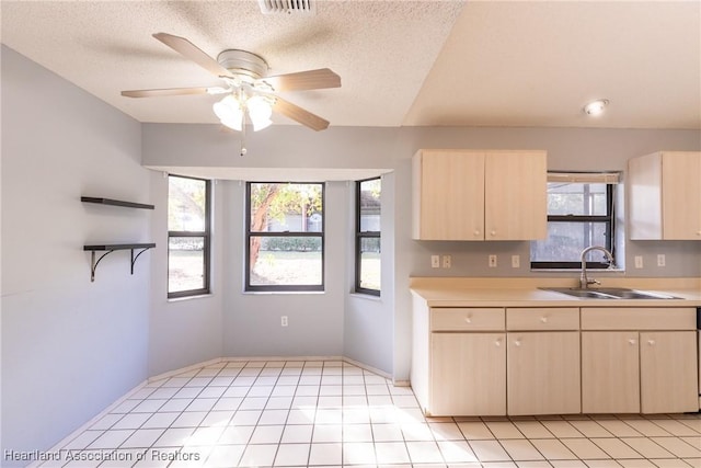 kitchen with ceiling fan, sink, a textured ceiling, and light brown cabinets