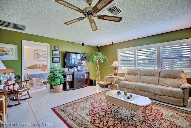 tiled living room featuring ceiling fan and a textured ceiling