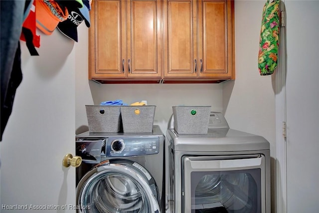 washroom featuring cabinets and independent washer and dryer