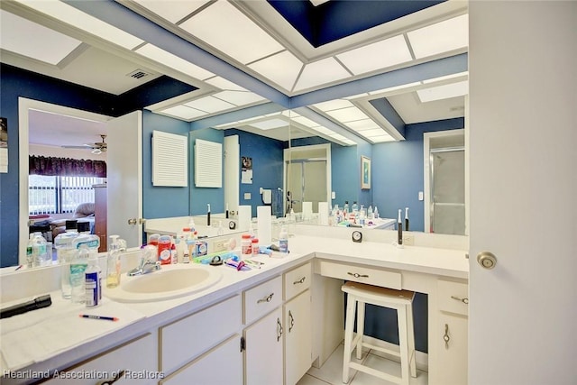 bathroom with tile patterned flooring, vanity, a shower with shower door, and ceiling fan