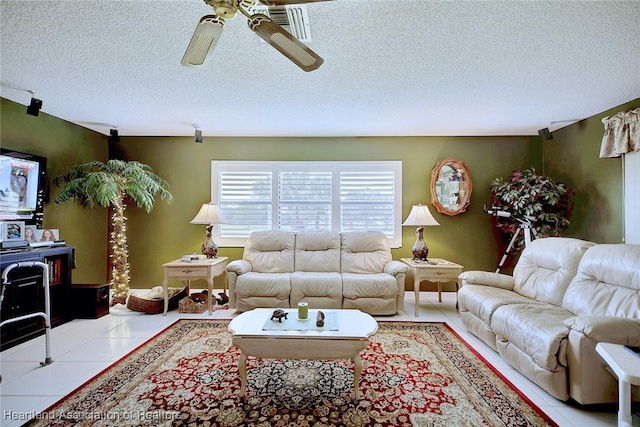 living room featuring ceiling fan, tile patterned floors, and a textured ceiling