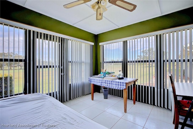 bedroom with multiple windows, light tile patterned floors, and ceiling fan