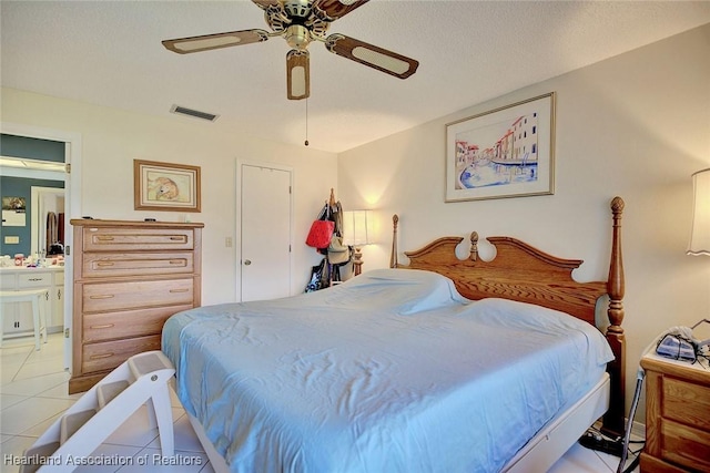 bedroom with light tile patterned flooring, ceiling fan, ensuite bath, and a textured ceiling