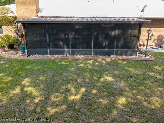 1900 N Riverdale Rd, Avon Park, FL 33825 - back of house featuring a sunroom, brick siding, a chimney, and a yard