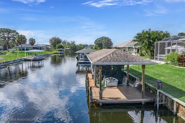 view of dock with a yard, a lanai, and a water view