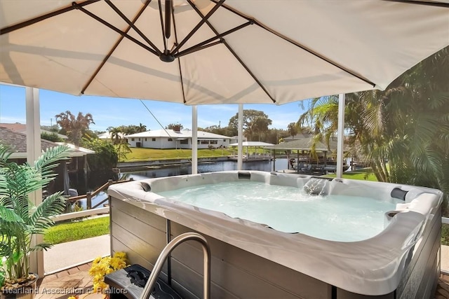 view of swimming pool featuring a water view and a hot tub