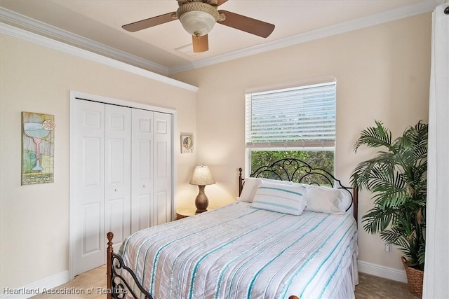 bedroom with crown molding, ceiling fan, and a closet