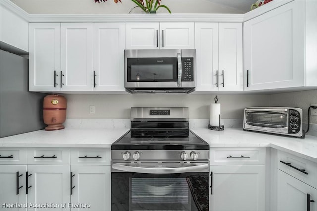 kitchen featuring light stone countertops, white cabinetry, and stainless steel appliances