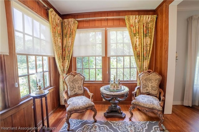 living area featuring plenty of natural light, hardwood / wood-style floors, and ornamental molding