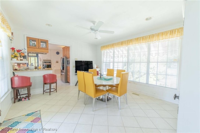 dining space featuring ceiling fan and ornamental molding