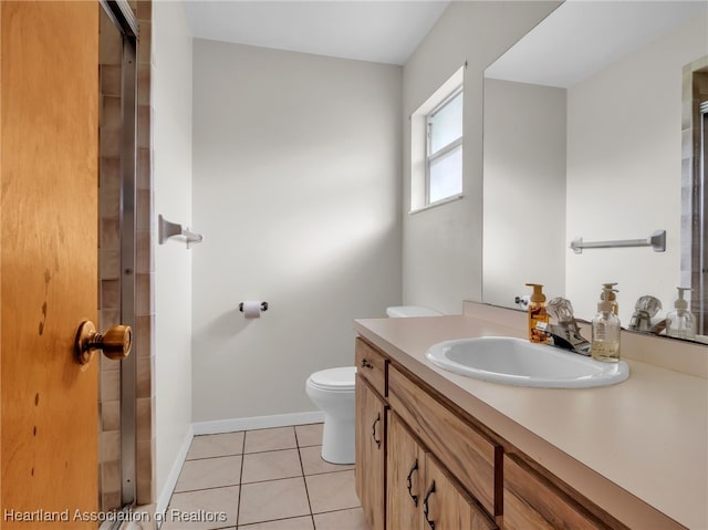 bathroom with tile patterned flooring, vanity, and toilet