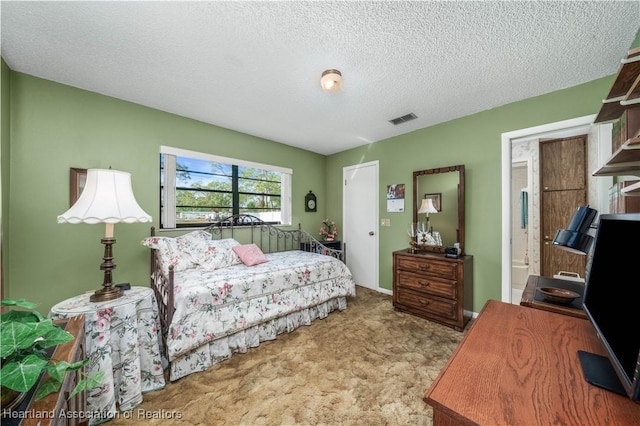 bedroom featuring baseboards, visible vents, carpet floors, and a textured ceiling