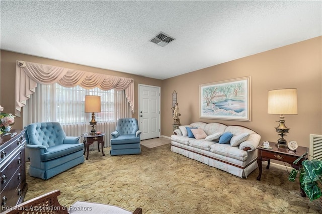 carpeted living room with visible vents, baseboards, and a textured ceiling