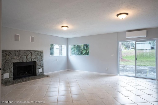 702 Catfish Rd, Lake Placid, FL 33852 - unfurnished living room featuring an AC wall unit, a textured ceiling, baseboards, a stone fireplace, and tile patterned floors