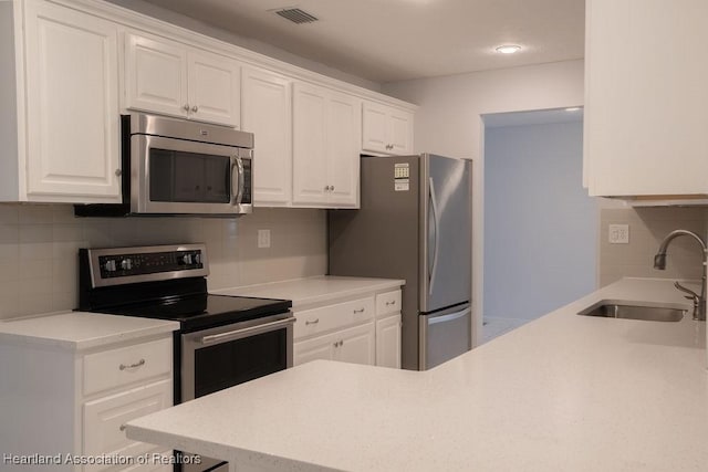 702 Catfish Rd, Lake Placid, FL 33852 - kitchen featuring stainless steel appliances, a sink, tasteful backsplash, white cabinets, and light countertops