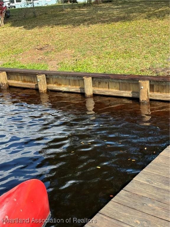 dock area featuring a water view and a yard