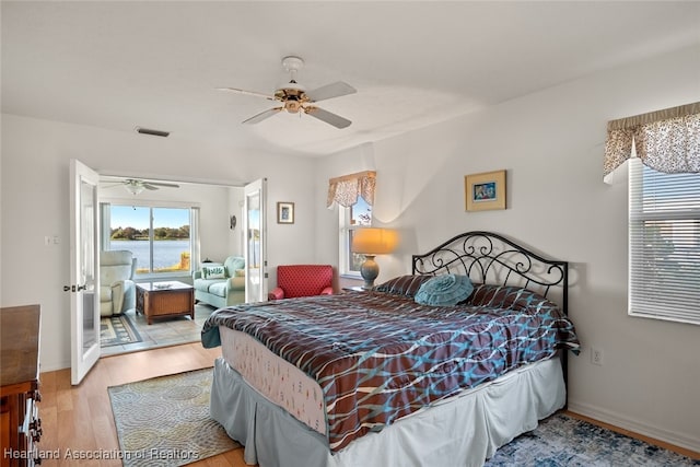 bedroom featuring a ceiling fan, baseboards, visible vents, and light wood finished floors