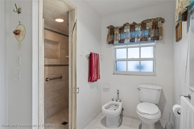 bathroom featuring tile patterned flooring, toilet, baseboards, a shower stall, and a bidet