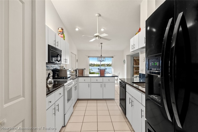 kitchen with light tile patterned floors, tasteful backsplash, dark countertops, black appliances, and white cabinetry