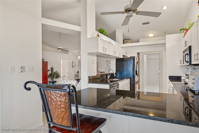 kitchen with appliances with stainless steel finishes, visible vents, white cabinetry, and a peninsula