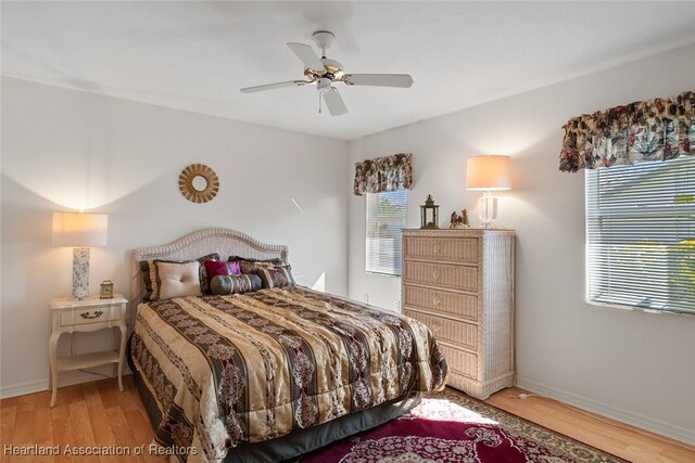 bedroom featuring ceiling fan, baseboards, and wood finished floors