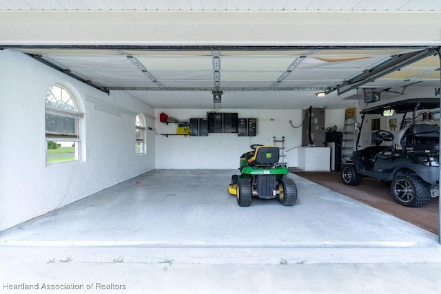 garage with electric panel, a garage door opener, and water heater