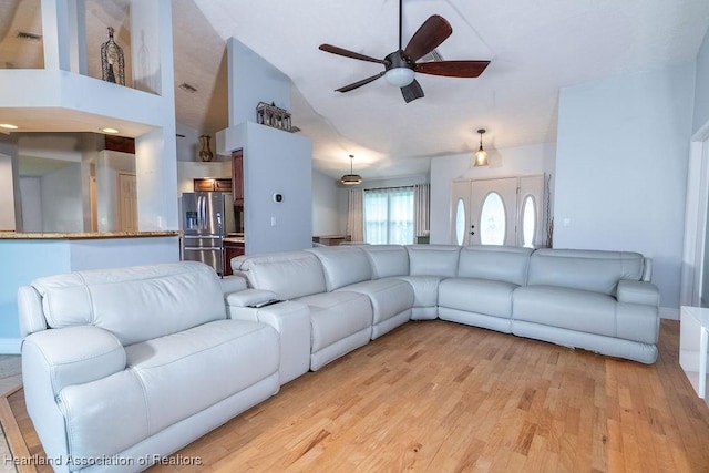 unfurnished living room with light wood-type flooring, high vaulted ceiling, and ceiling fan