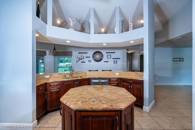 kitchen featuring dishwasher, a towering ceiling, a center island, and sink