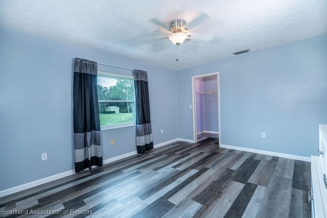 unfurnished room with dark hardwood / wood-style floors, ceiling fan, and a textured ceiling