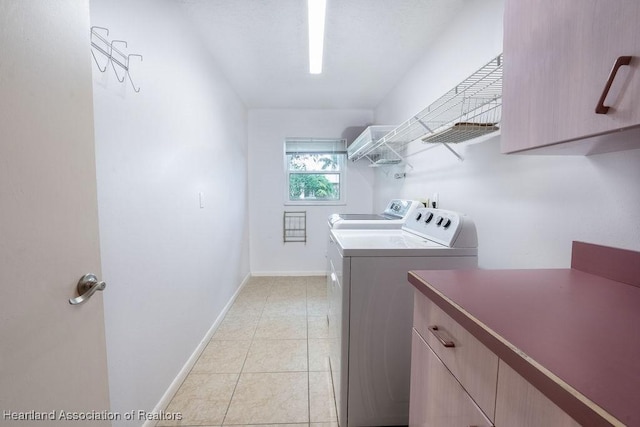 clothes washing area featuring washer and clothes dryer and light tile patterned floors