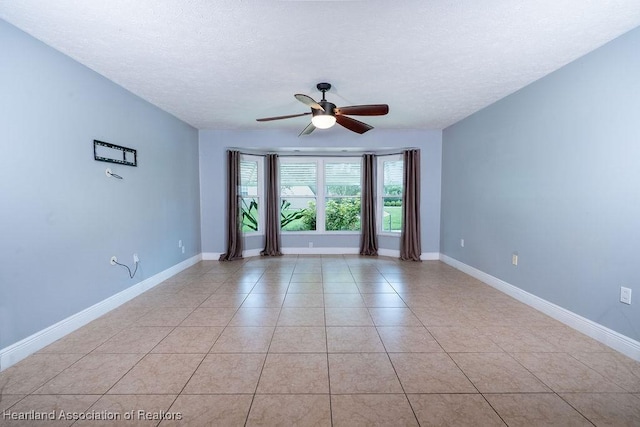 tiled spare room with ceiling fan and a textured ceiling