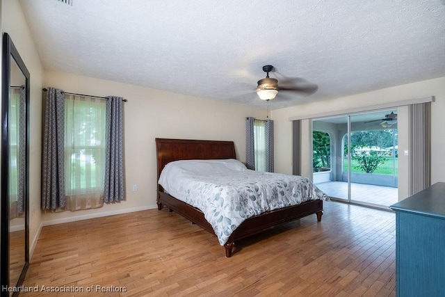 bedroom featuring access to outside, ceiling fan, light hardwood / wood-style flooring, and a textured ceiling