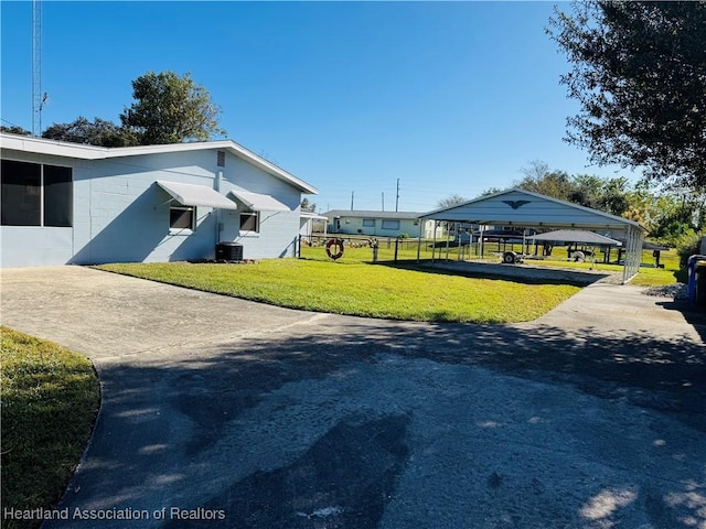 view of home's exterior with a carport, a yard, and central AC