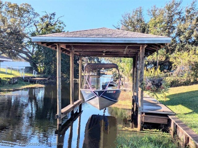 view of dock featuring a water view and a lawn